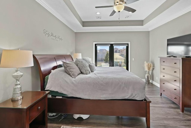 bedroom with baseboards, wood finished floors, access to exterior, a tray ceiling, and french doors