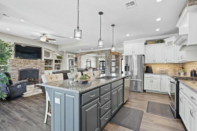 kitchen with gray cabinetry, a sink, white cabinetry, visible vents, and appliances with stainless steel finishes