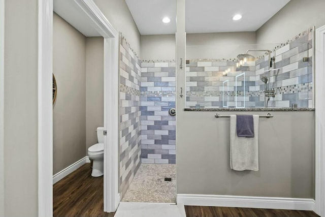 full bath with wood finished floors, walk in shower, toilet, and baseboards