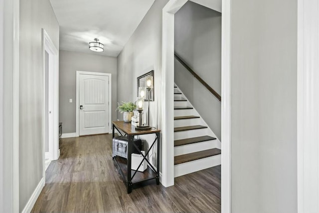 entryway with stairs, baseboards, and wood finished floors