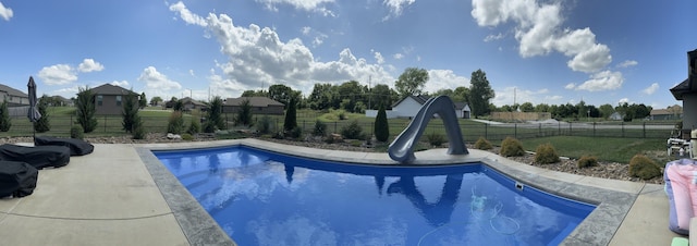 view of swimming pool featuring a fenced in pool, a water slide, a fenced backyard, and a yard