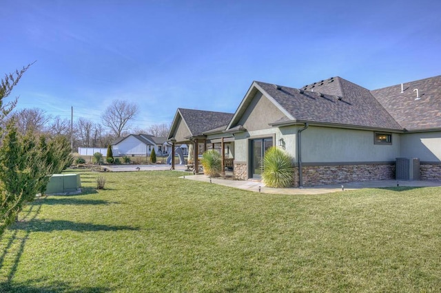 view of home's exterior with stone siding, roof with shingles, a yard, and stucco siding