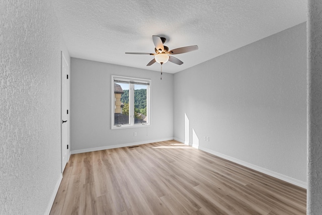185 Eagle Pointe Dr, Branson, MO 65616 - spare room with a ceiling fan, light wood finished floors, a textured wall, and a textured ceiling