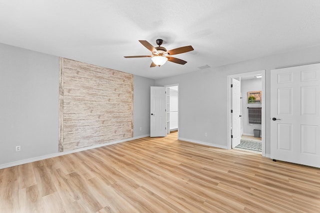 185 Eagle Pointe Dr, Branson, MO 65616 - unfurnished bedroom with light wood-style floors, connected bathroom, a walk in closet, and a ceiling fan