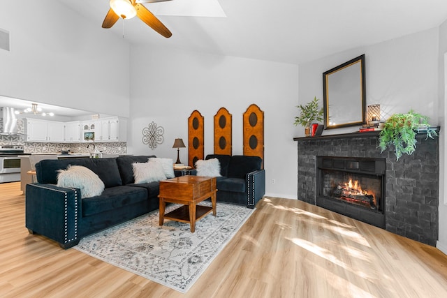 185 Eagle Pointe Dr, Branson, MO 65616 - living area featuring a glass covered fireplace, light wood-type flooring, a ceiling fan, a chandelier, and lofted ceiling