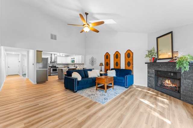 185 Eagle Pointe Dr, Branson, MO 65616 - living area featuring a ceiling fan, a glass covered fireplace, high vaulted ceiling, and light wood-style floors