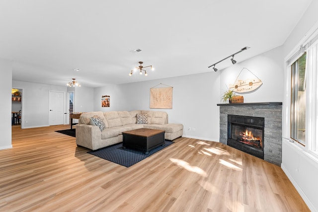185 Eagle Pointe Dr, Branson, MO 65616 - living room featuring a fireplace, wood finished floors, and a chandelier