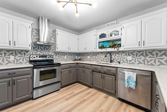 185 Eagle Pointe Dr, Branson, MO 65616 - kitchen featuring gray cabinets, appliances with stainless steel finishes, wall chimney range hood, white cabinetry, and a textured ceiling