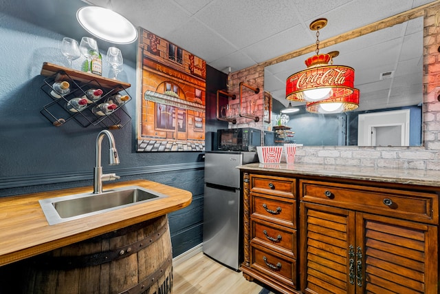 185 Eagle Pointe Dr, Branson, MO 65616 - kitchen with freestanding refrigerator, wood counters, a drop ceiling, light wood-style flooring, and brown cabinets