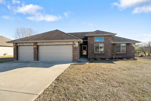 view of front of home with brick siding, roof with shingles, a front yard, a garage, and driveway