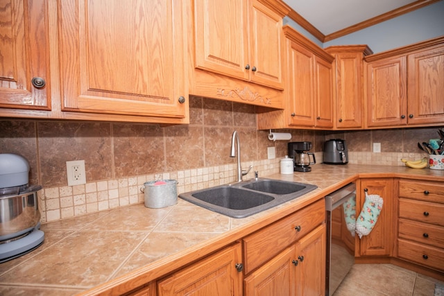 kitchen with dishwasher, tile countertops, a sink, and crown molding