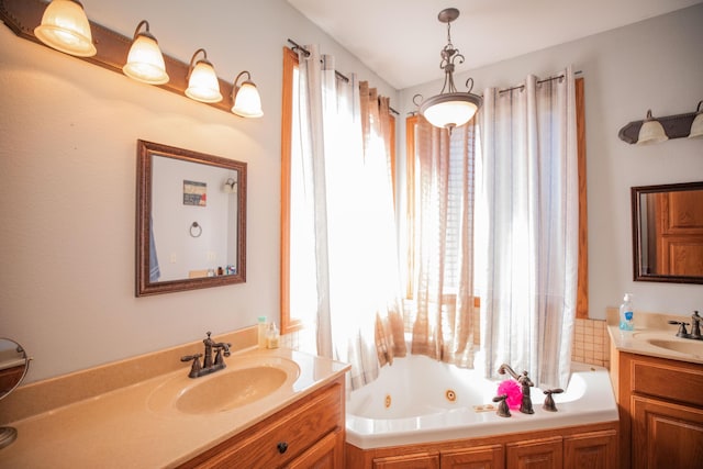 full bathroom featuring a tub with jets, two vanities, and a sink