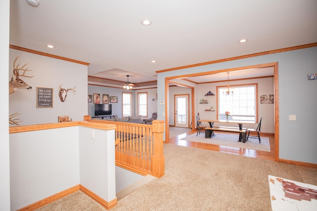 corridor featuring baseboards, ornamental molding, wood finished floors, an inviting chandelier, and recessed lighting