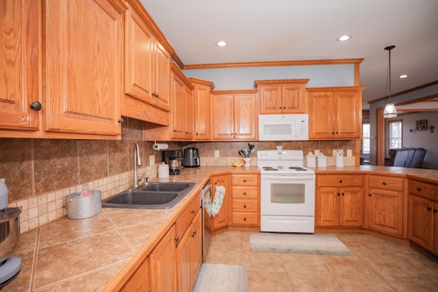 kitchen with white appliances, decorative backsplash, tile countertops, hanging light fixtures, and a sink