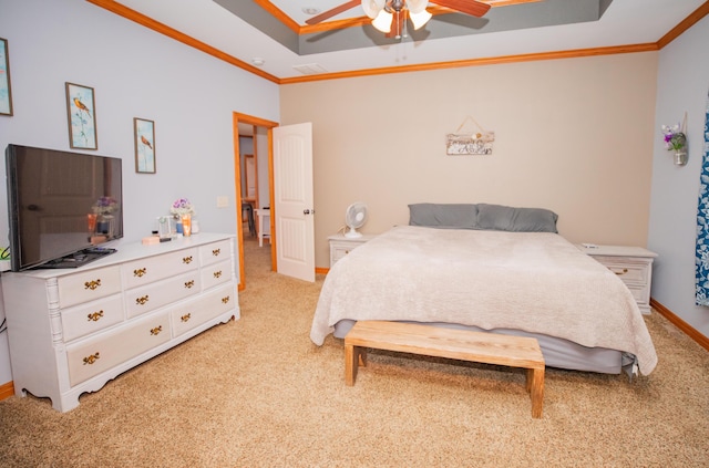 bedroom featuring light colored carpet, visible vents, baseboards, ornamental molding, and a tray ceiling