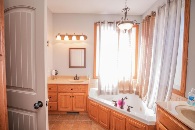 full bath with visible vents, two vanities, a sink, tile patterned flooring, and a bath