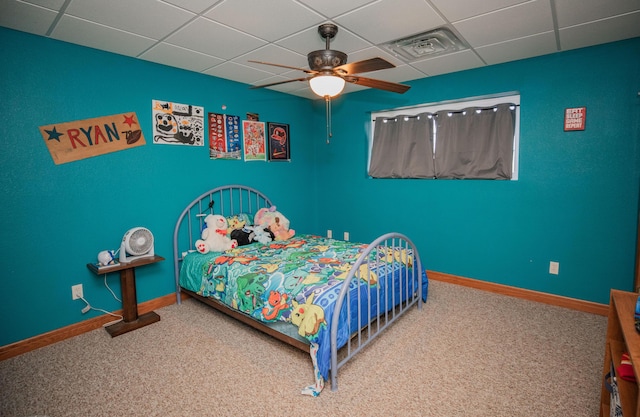 bedroom with baseboards, visible vents, a ceiling fan, a drop ceiling, and carpet flooring