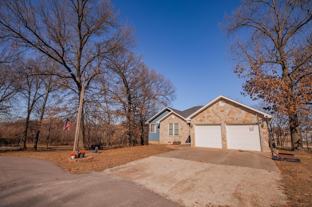 ranch-style house with a garage, stone siding, and concrete driveway