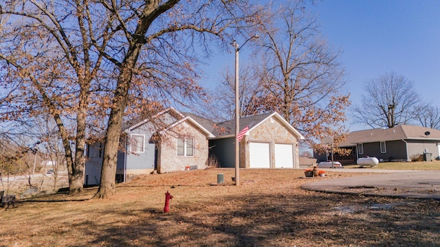 ranch-style home featuring an attached garage and stone siding