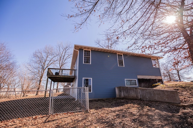 rear view of house with a gate, fence, and a wooden deck