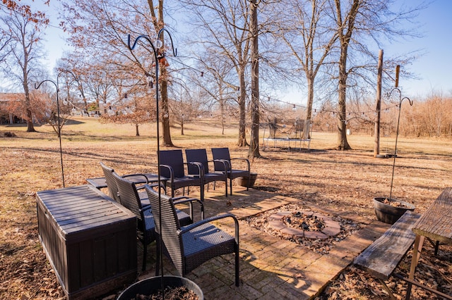 view of patio / terrace with a trampoline and an outdoor fire pit