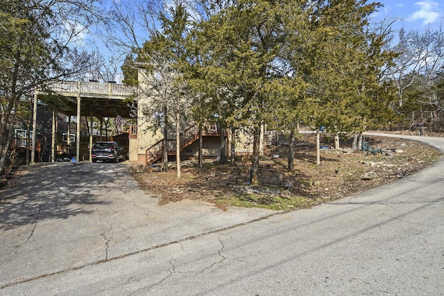 view of front of house featuring stairs, aphalt driveway, and a carport