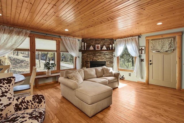 living area with wood ceiling, light wood-style flooring, recessed lighting, and a stone fireplace