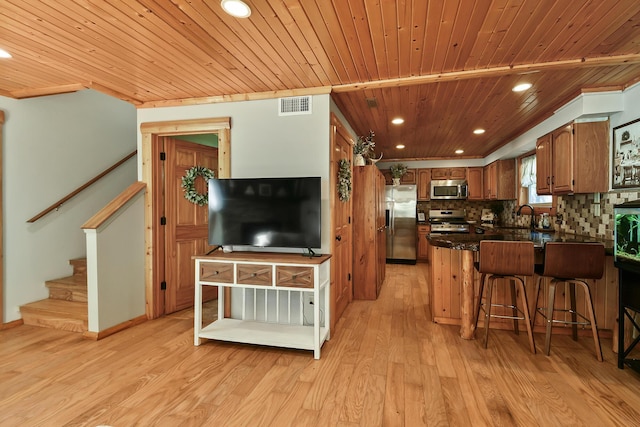 kitchen featuring visible vents, decorative backsplash, dark countertops, light wood-style flooring, and stainless steel appliances