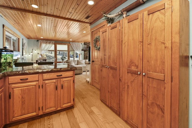 kitchen featuring wooden ceiling, open floor plan, dark stone countertops, light wood-type flooring, and recessed lighting