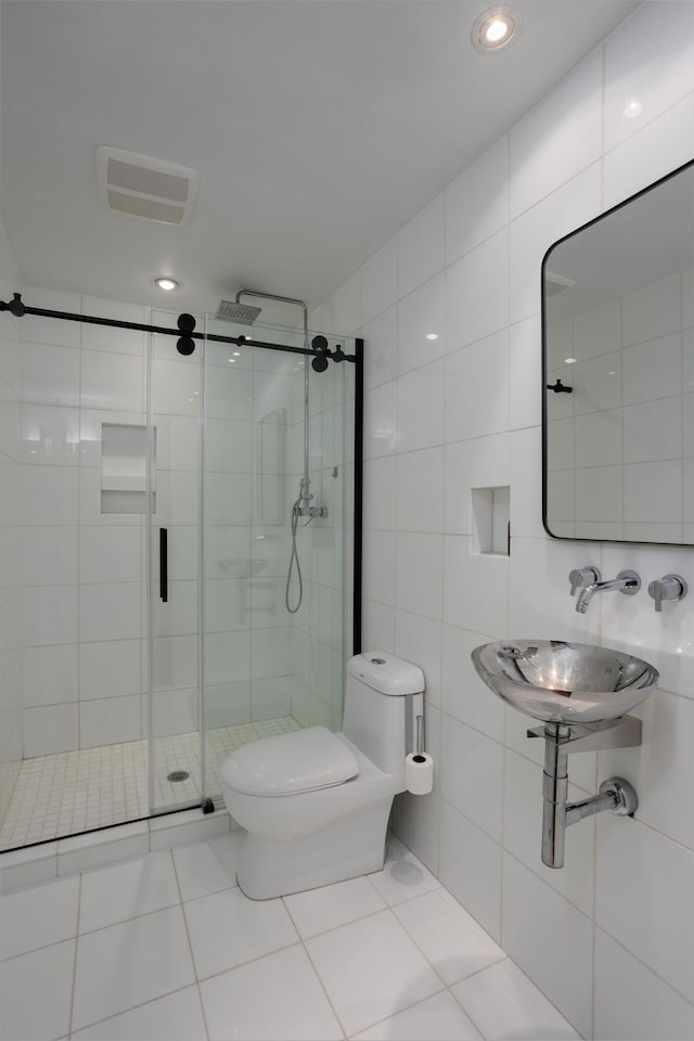 full bath featuring toilet, a sink, visible vents, tile walls, and a stall shower