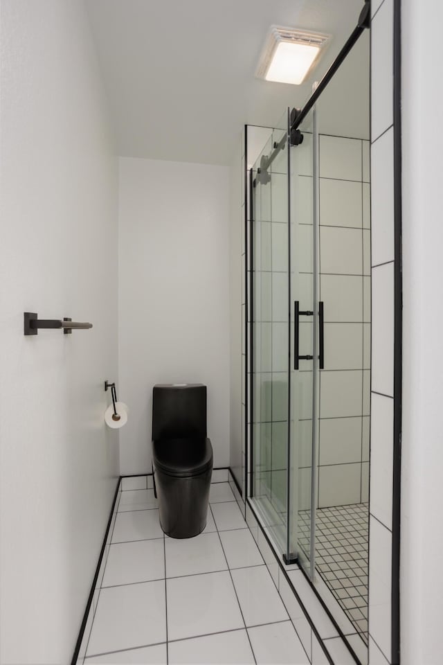 bathroom featuring a stall shower, tile patterned flooring, and toilet