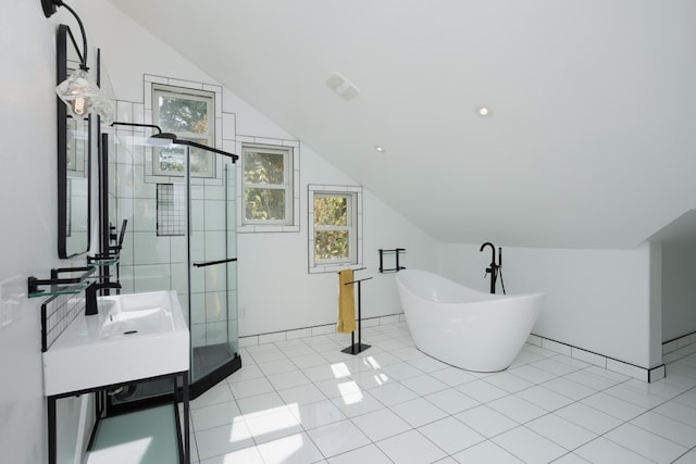 bathroom with lofted ceiling, a shower stall, a freestanding bath, and tile patterned floors