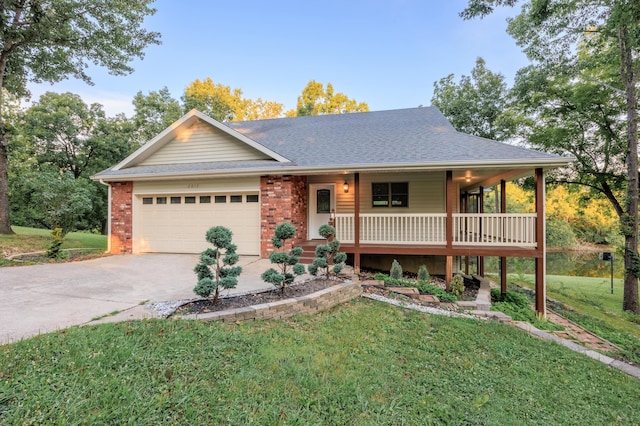 view of front of home featuring a shingled roof, concrete driveway, covered porch, a front yard, and a garage