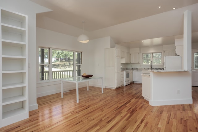 kitchen with white appliances, a sink, white cabinetry, light countertops, and light wood-type flooring