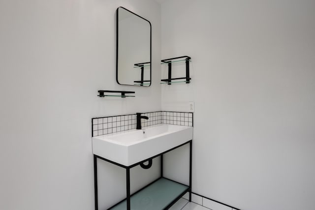 bathroom featuring a sink and backsplash