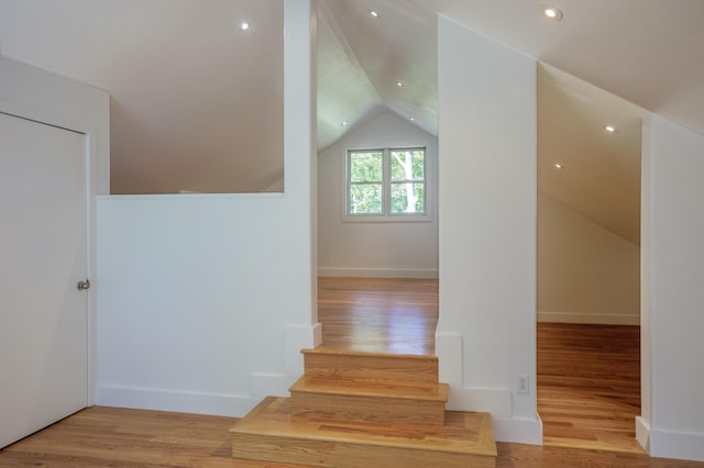 additional living space with lofted ceiling, wood finished floors, and baseboards