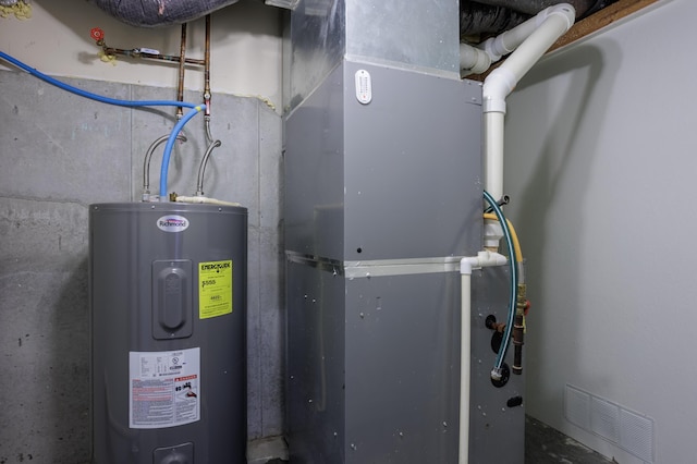 utility room featuring electric water heater and visible vents