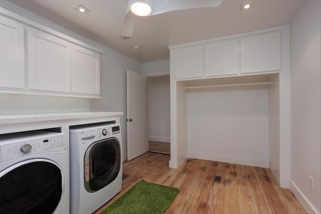 clothes washing area with cabinet space, light wood-style flooring, a ceiling fan, washing machine and dryer, and baseboards