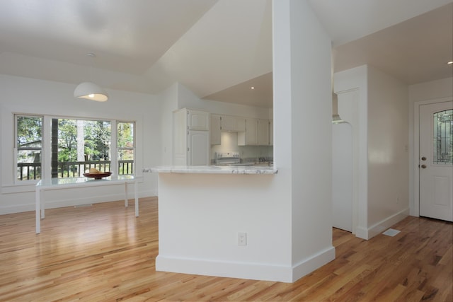 kitchen with decorative light fixtures, light wood finished floors, light countertops, range, and baseboards