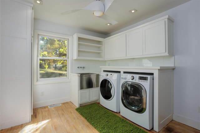 laundry room featuring light wood-style floors, cabinet space, ceiling fan, and washer and clothes dryer