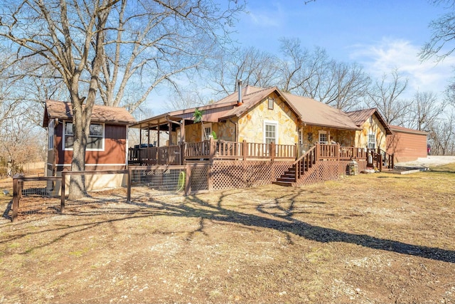 view of front of home featuring stone siding, stairs, and a wooden deck