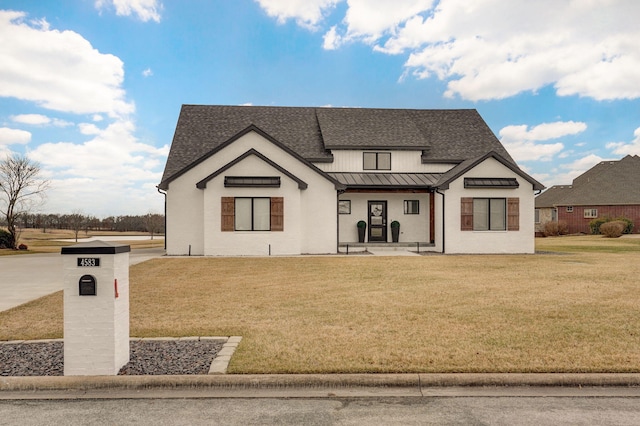 modern inspired farmhouse featuring metal roof, roof with shingles, a standing seam roof, a front lawn, and a porch