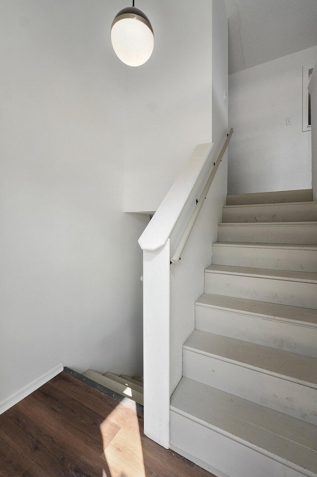 stairs featuring wood finished floors