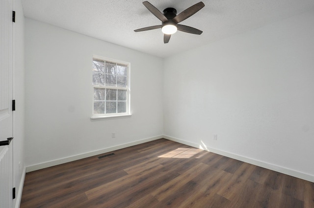 unfurnished room featuring baseboards, a textured ceiling, visible vents, and dark wood-type flooring