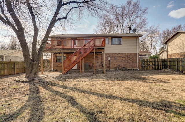 back of property featuring a fenced backyard, stairs, a wooden deck, and brick siding