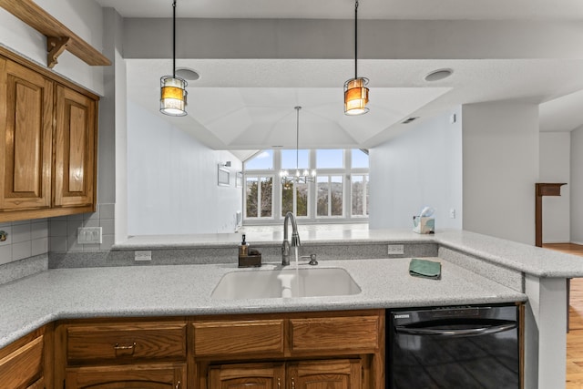 kitchen featuring brown cabinetry, black dishwasher, pendant lighting, and a sink