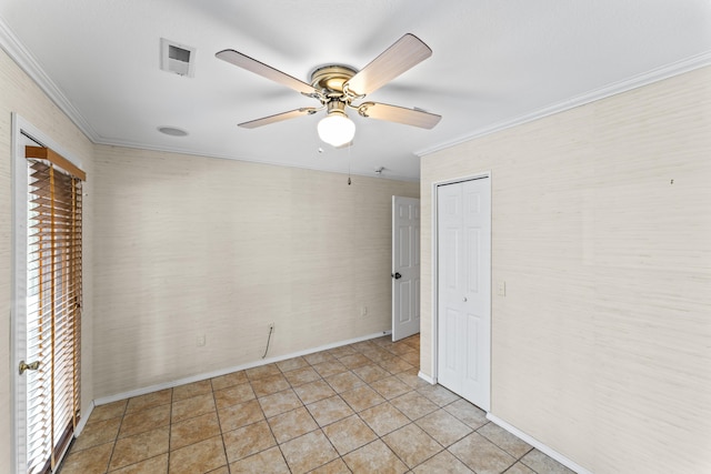 spare room featuring light tile patterned floors, baseboards, visible vents, a ceiling fan, and ornamental molding