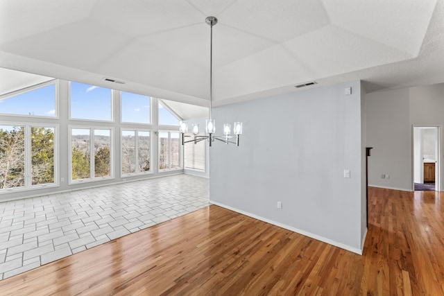 unfurnished dining area with vaulted ceiling, visible vents, a notable chandelier, and wood finished floors