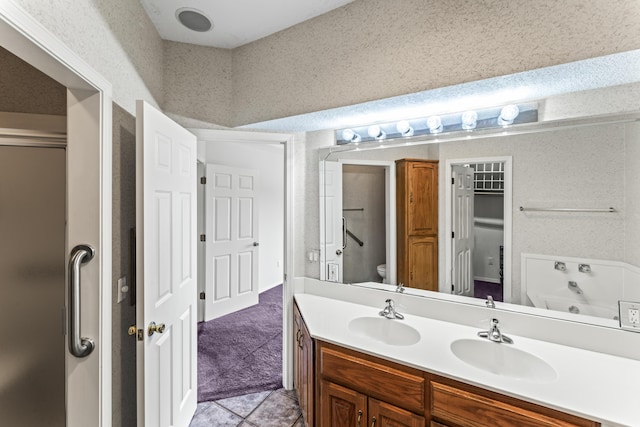 bathroom featuring a sink, a shower stall, toilet, and double vanity