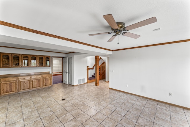 unfurnished living room featuring light tile patterned floors, baseboards, visible vents, stairway, and crown molding